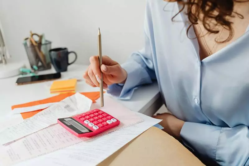 Une femme tenant un stylo et regardant des papiers.