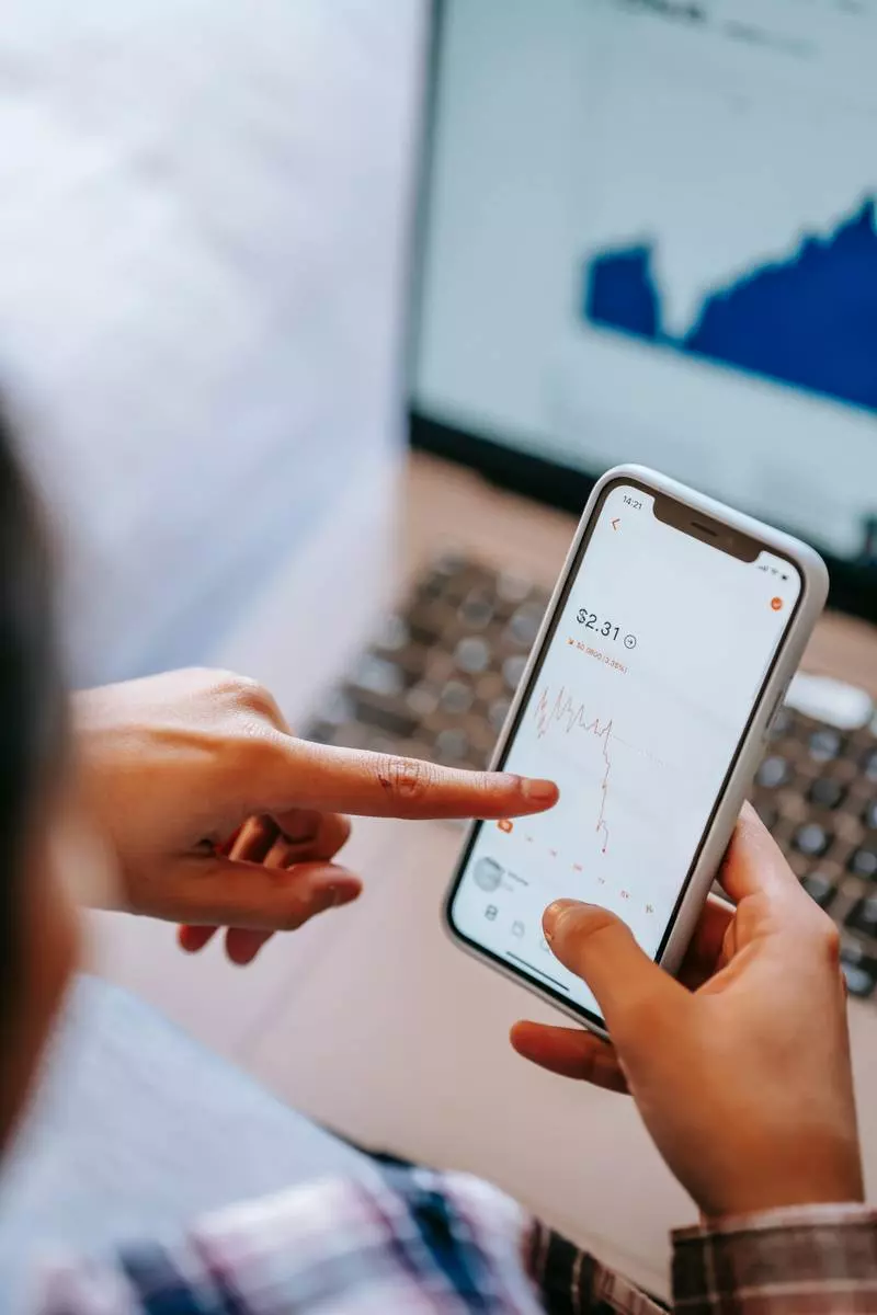 Une personne observant un graphique de taux de change sur son téléphone.