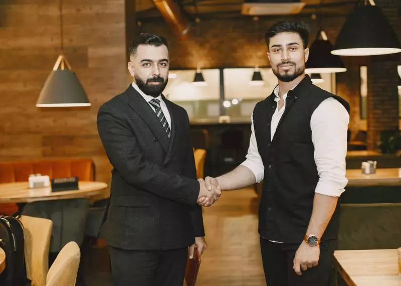 Hommes d'affaires se serrant la main de manière confidentielle.